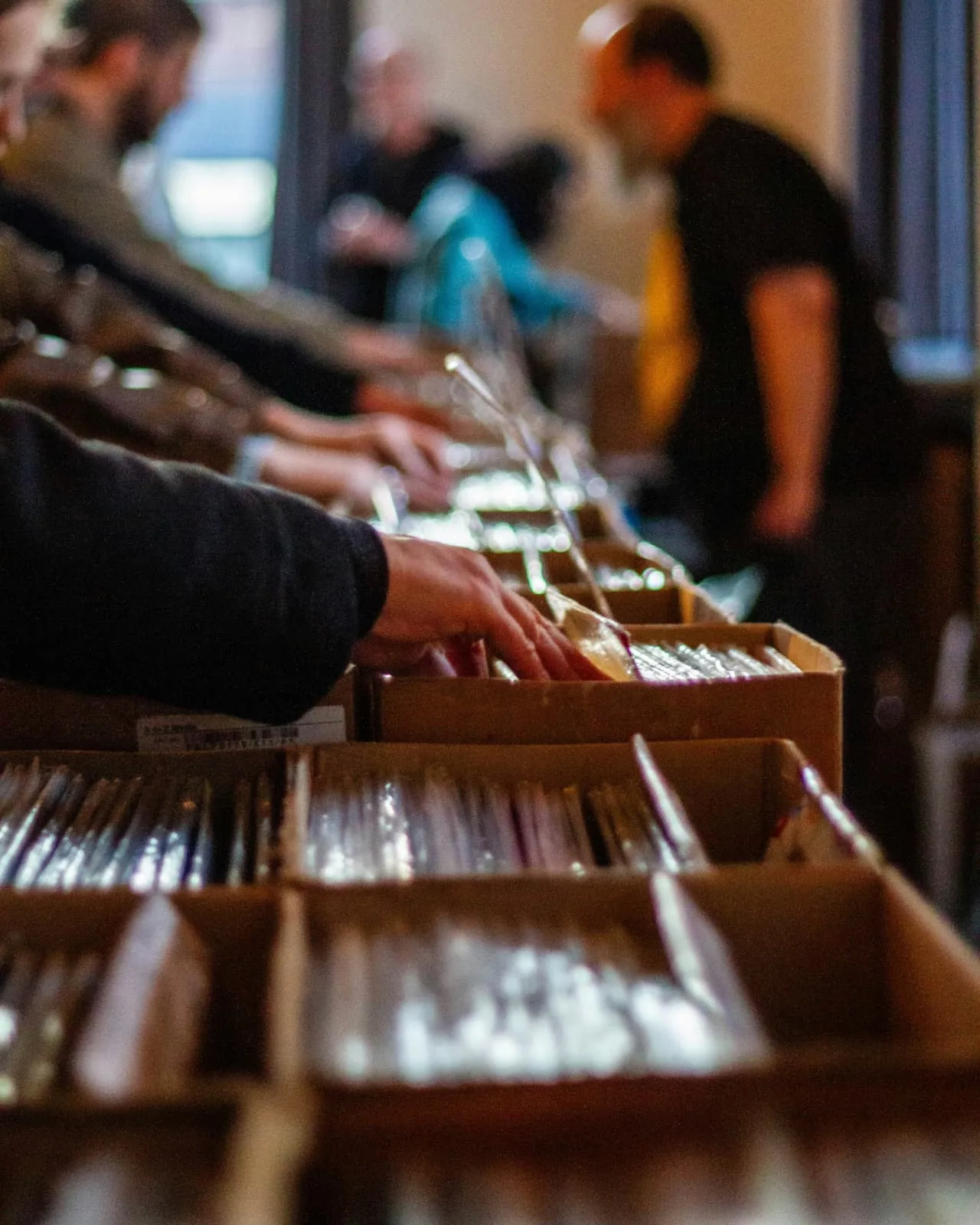 Shoppers flipping through crates of records at a record shop.